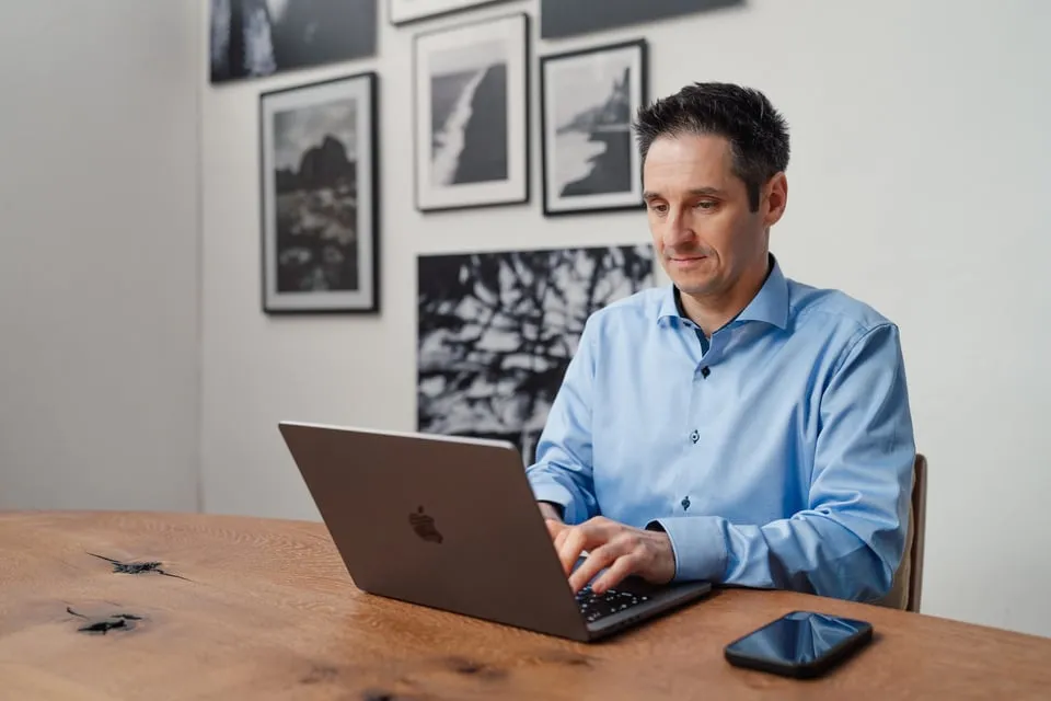 Alexander Pippir an einem Tisch mit Laptop