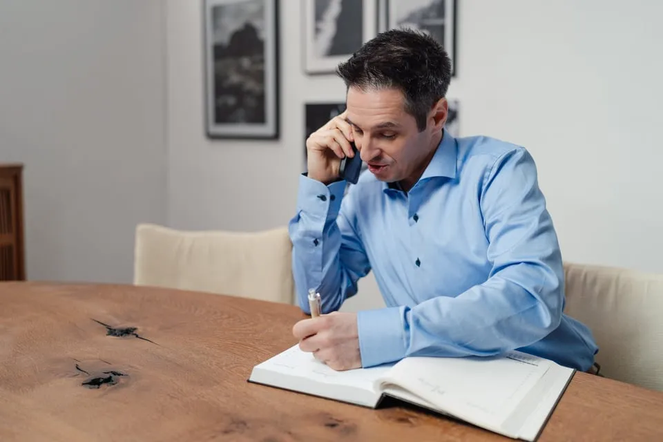 Alex Pippir telefoniert und macht sich Notizen